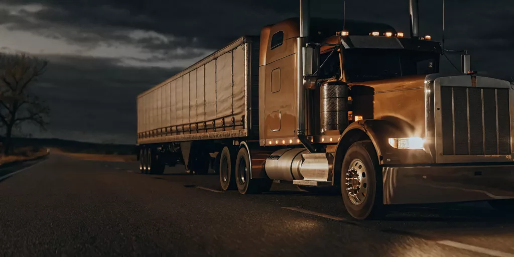 Semi-truck on a highway at dusk with dramatic lighting